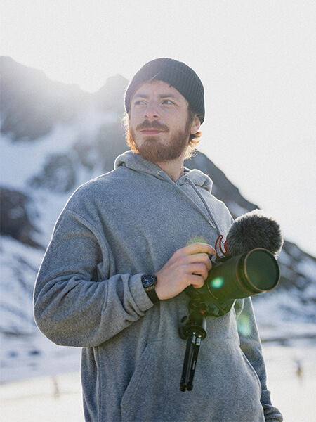 CyrilMP4 tenant un appareil photo Canon dans les mains dans un paysage nordique 