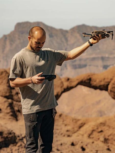 homme qui porte un drone à bout de bras