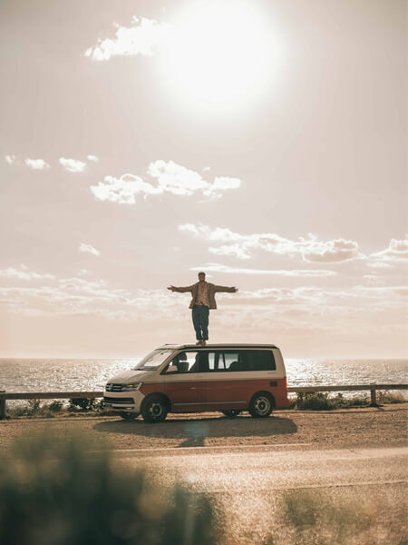 homme debout sur son van à la mer