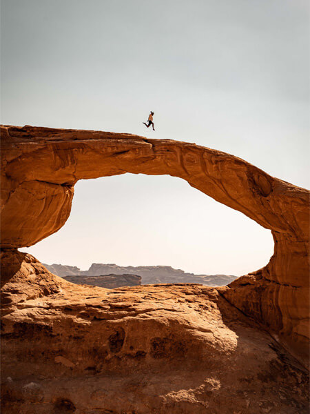 homme qui saute au dessus des rochers