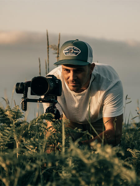 homme qui film couché dans l'herbe