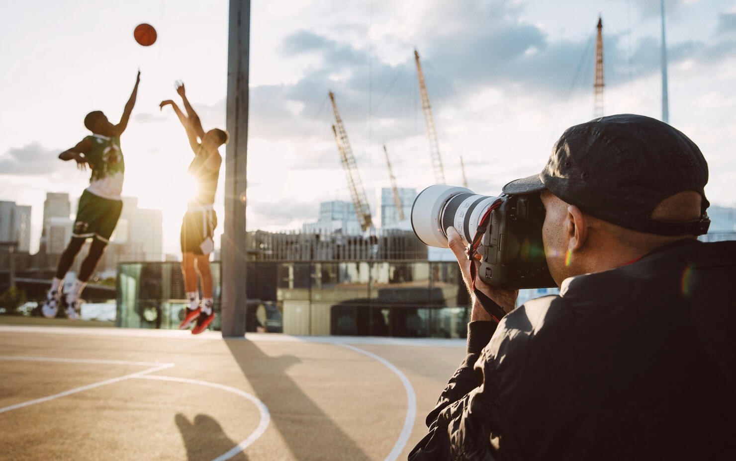 Photographe capturant un match de basketball avec un boîtier Canon