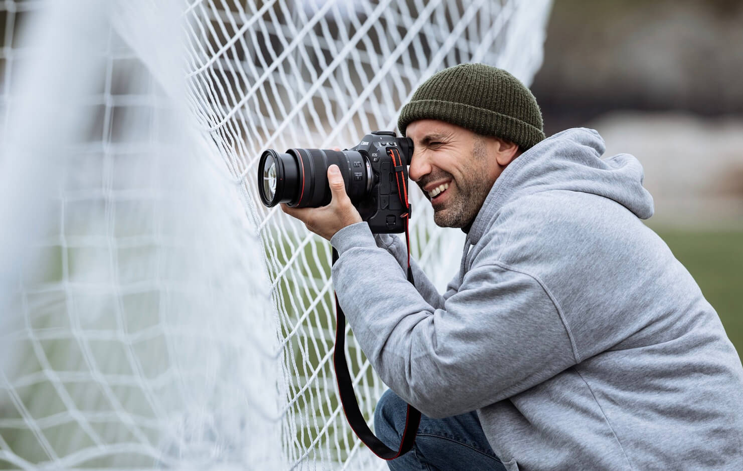 Photographe derrière une cage de football avec un Canon EOS R1