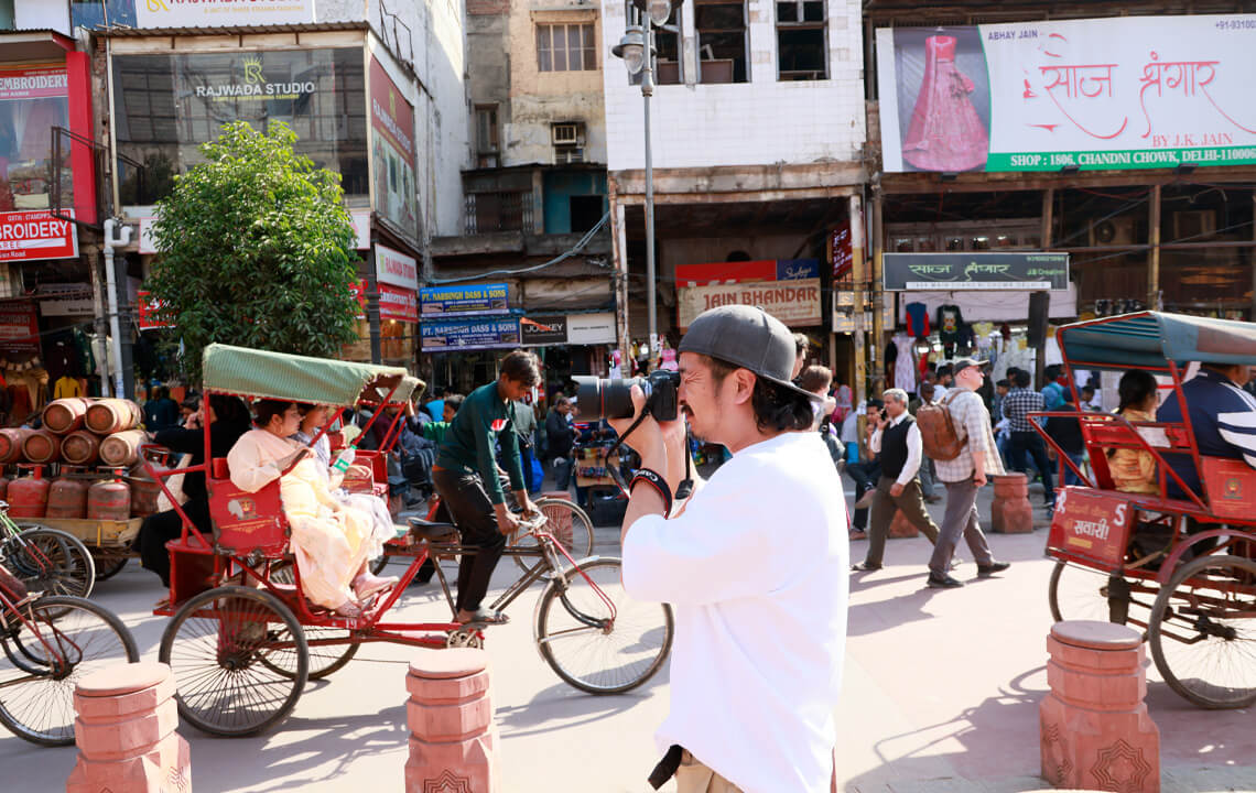 homme qui prend en photo la foule dans la rue en Inde