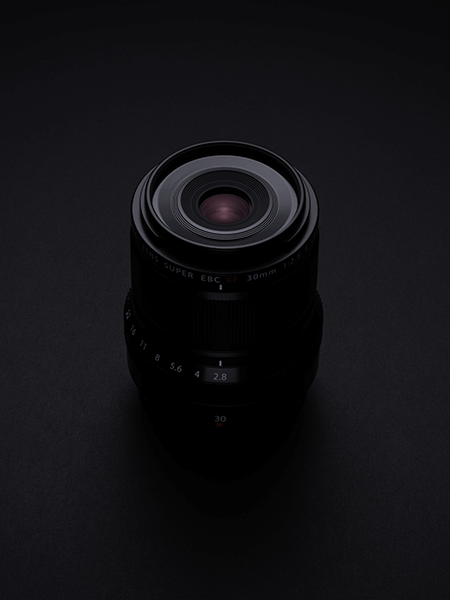 Objectif Fujifilm 30mm macro noir sur fond noir en studio